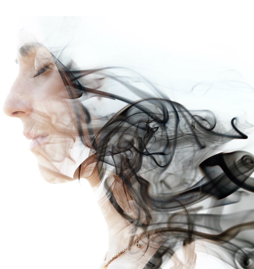 The side profile of a woman dispersing into smoke representing serenity.